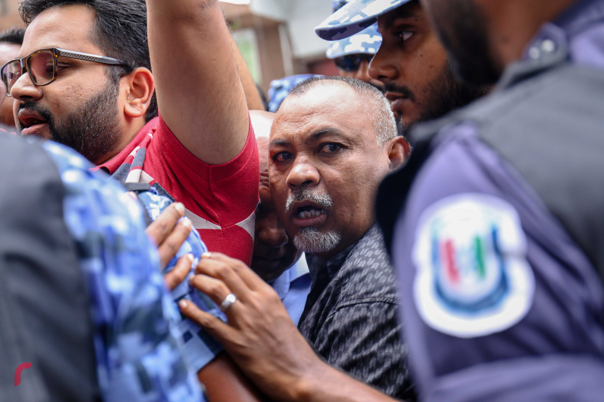 ޖުލައި 23، 2018: އިލެކްޝަންސް ކޮމިޝަނުގެ ރައީސް އަހުމަދު ޝަރީފު އިސްތިއުފާދިނުމަށާއި މިނިވަން އިންސާފުވެރި އިންތިހާބެއް ބޭއްވުމަށް ގޮވާލައި އިލެކްޝަންސް ކޮމިޝަނުގެ އޮފީސް ހުރި ސަރަހައްދުގައި ގުޅިފައިވާ އިއްތިހާދުގެ މެމްބަރުން ކުރި މުޒާހަރާ ރޫޅާލުމަށް ފުލުހުން ހަރަކާތްތެރިވަނީ، މި އެއްވުމުގައި މިނިވަން އިންތިހާބަކަށް ގޮވާލައި ޝުއޫރު ފާޅުކޮށްފައިވާ ބޯޑު ފަދަ ތަކެތި ވަނީ ބޭނުންކޮށްފައި-- ފޮޓޯ: މުހައްމަދު ޝަރުހާން / ރާއްޖެ އެމްވީ