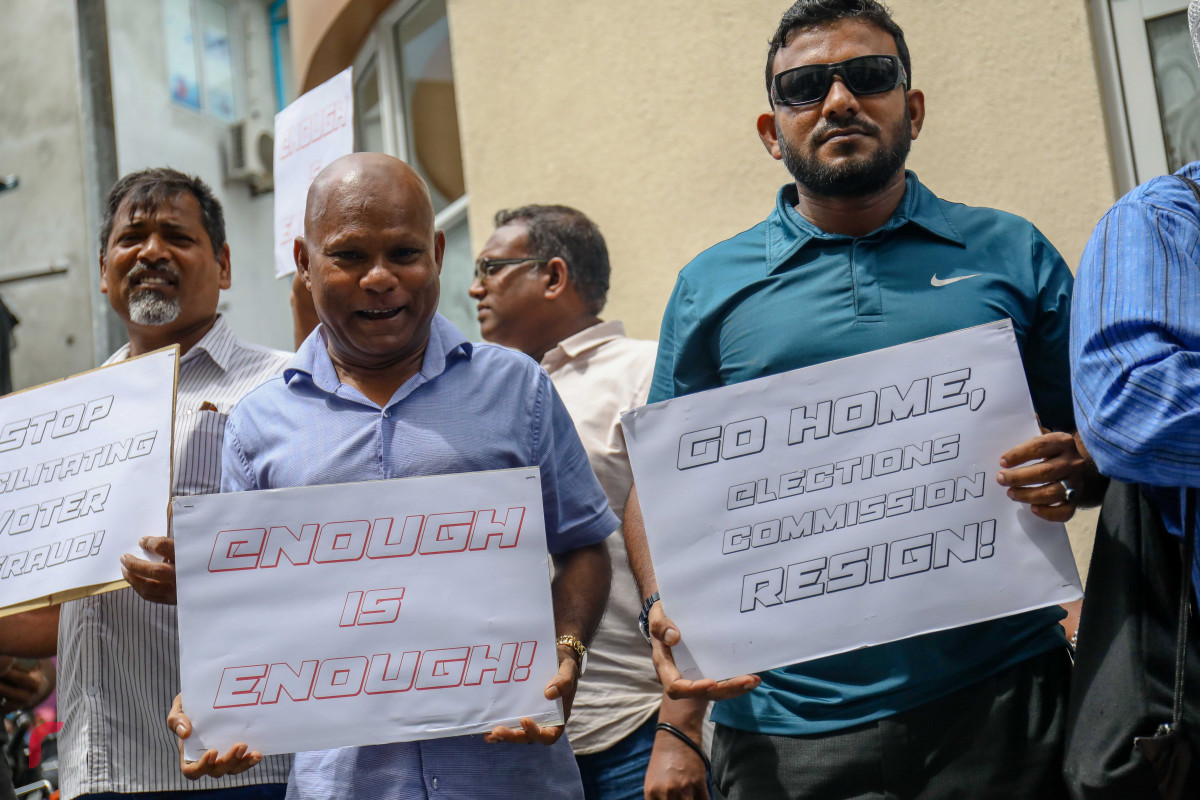 ޖުލައި 23، 2018: އިލެކްޝަންސް ކޮމިޝަނުގެ ރައީސް އަހުމަދު ޝަރީފު އިސްތިއުފާދިނުމަށާއި މިނިވަން އިންސާފުވެރި އިންތިހާބެއް ބޭއްވުމަށް ގޮވާލައި އިލެކްޝަންސް ކޮމިޝަނުގެ އޮފީސް ހުރި ސަރަހައްދުގައި ގުޅިފައިވާ އިއްތިހާދުގެ މެމްބަރުން ކުރި މުޒާހަރާގެ ތެރެއިން، މި އެއްވުމުގައި ގިނަ އަދަދެއްގެ ފަރާތްތަކުން އެއްވެ އަޑުއުފުލާފައިވާއިރު ފުލުހުންވަނީ އިލެކްޝަންސް ކޮމިޝަން ސަރަހައްދުން މުޒާހަރާގެ ބައިވެރިން ދުރުކޮށް އެއްވުން ރޫޅާލާފައި -- ފޮޓޯ: މުހައްމަދު ޝަރުހާން / ރާއްޖެ އެމްވީ