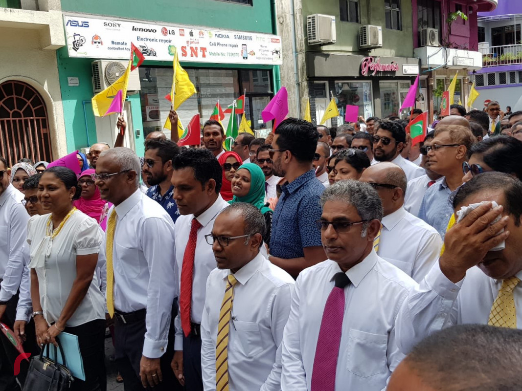 ޖުލައި 27، 2018: ގުޅިފައިވާ އިއްތިހާދުގެ ރިޔާސީ ކެންޑިޑޭޓް އިބްރާހިމް މުހައްމަދު ސޯލިހް (އިބޫ) ރިޔާސީ އިންތިހާބުގައި ވާދަކުރެއްވުމަށް އިލެކްޝަންސް ކޮމިޝަނަށް ފޯމް ހުށަހެޅުއްވުމަށް ކުރިޔަށް ގެންދިޔަ ހަރަކާތުގެ ތެރެއިން އެމްޑީޕީ އޮފީސް ކުރިމަތިން އިލެކްޝަންސް ކޮމިޝަނަށް އިދިކޮޅު ފަރާތްތަކުން ހިންގަވާފައި ވަޑައިގަންނަވަނީ.