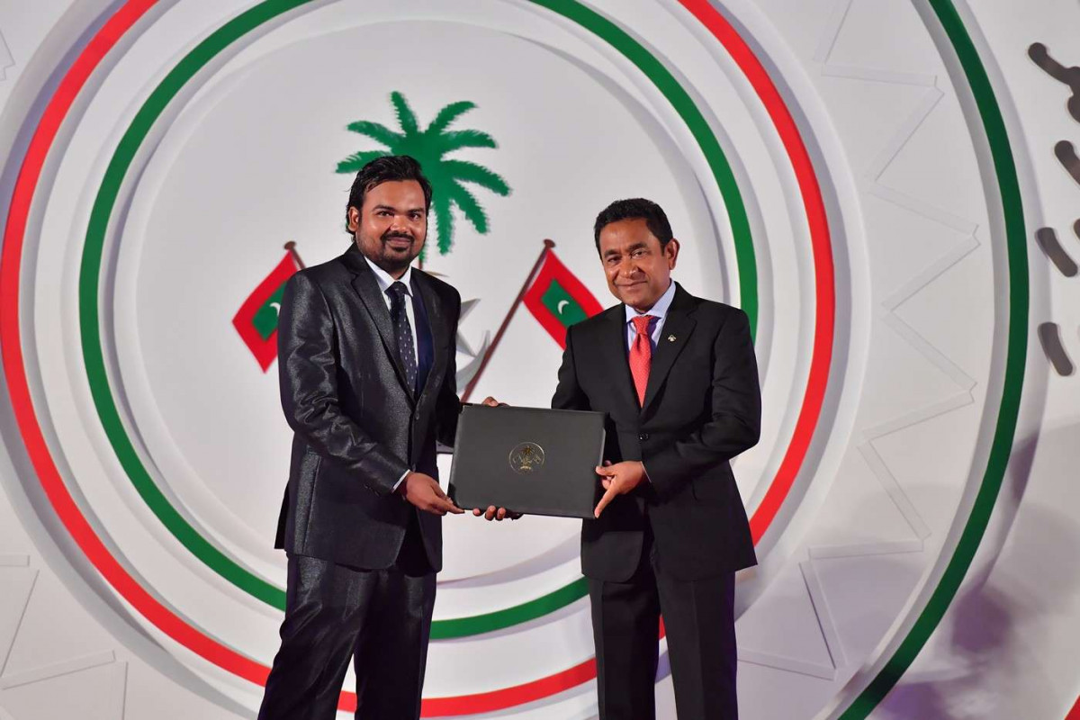 ޖުލައި 26، 2018: ރާއްޖޭގެ މިނިވަންކަމަށް 53 އަހަރު ފުރުން ފާހަގަކުރުމަށް ޖުމްހޫރީ މައިދާނުގައި ބޭއްވި ރަސްމިއްޔާތުގެ ތެރެއިން، ސަރުކާރުގެ ގިނަ އިސްވެރިން ބައިވެރިވި މި ހަފްލާފައި ޝަރަފްވެރިކަމުގެ ގައުމީ އިނާމް ފަސް ބޭފުޅަކަށް އަދި ހިތްވަރު ދިނުމުގެ ގައުމީ އިނާމް 15 ބޭފުޅަކަށް ރައީސް އަބްދުﷲ ޔާމީން އަބްދުލްގައްޔޫމް ވަނީ ދެއްވާފައި