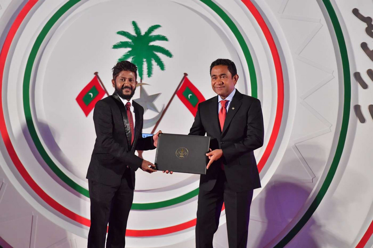 ޖުލައި 26، 2018: ރާއްޖޭގެ މިނިވަންކަމަށް 53 އަހަރު ފުރުން ފާހަގަކުރުމަށް ޖުމްހޫރީ މައިދާނުގައި ބޭއްވި ރަސްމިއްޔާތުގެ ތެރެއިން، ސަރުކާރުގެ ގިނަ އިސްވެރިން ބައިވެރިވި މި ހަފްލާފައި ޝަރަފްވެރިކަމުގެ ގައުމީ އިނާމް ފަސް ބޭފުޅަކަށް އަދި ހިތްވަރު ދިނުމުގެ ގައުމީ އިނާމް 15 ބޭފުޅަކަށް ރައީސް އަބްދުﷲ ޔާމީން އަބްދުލްގައްޔޫމް ވަނީ ދެއްވާފައި