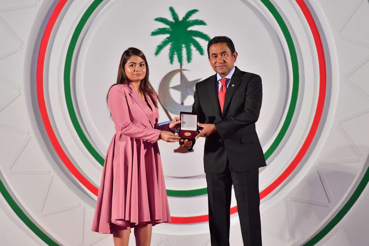 ޖުލައި 26، 2018: ރާއްޖޭގެ މިނިވަންކަމަށް 53 އަހަރު ފުރުން ފާހަގަކުރުމަށް ޖުމްހޫރީ މައިދާނުގައި ބޭއްވި ރަސްމިއްޔާތުގެ ތެރެއިން، ސަރުކާރުގެ ގިނަ އިސްވެރިން ބައިވެރިވި މި ހަފްލާފައި ޝަރަފްވެރިކަމުގެ ގައުމީ އިނާމް ފަސް ބޭފުޅަކަށް އަދި ހިތްވަރު ދިނުމުގެ ގައުމީ އިނާމް 15 ބޭފުޅަކަށް ރައީސް އަބްދުﷲ ޔާމީން އަބްދުލްގައްޔޫމް ވަނީ ދެއްވާފައި