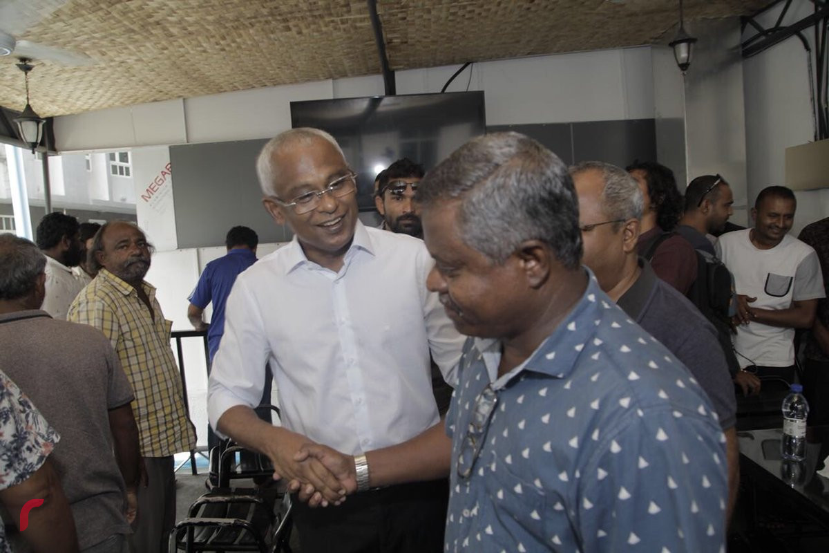 އޯގަސްޓް 4، 2018: ގުޅިފައިވާ އިއްތިހާދުން ރިޔާސީ އިންތިހާބަށް ތައްޔާރުވުމަށް ކުރިއަށްގެންދާ ހަރަކާތްތަކުގެ ތެރެއިން އިއްތިހާދުގެ ރިޔާސީ ކެންޑިޑޭޓް އިބްރާހިމް މުހައްމަދު ސޯލިހު މާލެ ސިޓީގައި ދޮރުން ދޮރަށް ހިންގަވާފައިވާއިރު ވަނީ ރައްޔިތުންގެ ހާލުބައްލަވާފައި