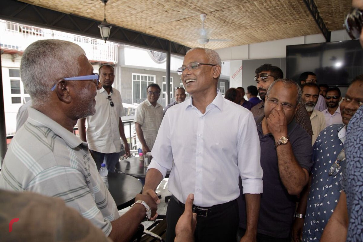 އޯގަސްޓް 4، 2018: ގުޅިފައިވާ އިއްތިހާދުން ރިޔާސީ އިންތިހާބަށް ތައްޔާރުވުމަށް ކުރިއަށްގެންދާ ހަރަކާތްތަކުގެ ތެރެއިން އިއްތިހާދުގެ ރިޔާސީ ކެންޑިޑޭޓް އިބްރާހިމް މުހައްމަދު ސޯލިހު މާލެ ސިޓީގައި ދޮރުން ދޮރަށް ހިންގަވާފައިވާއިރު ވަނީ ރައްޔިތުންގެ ހާލުބައްލަވާފައި