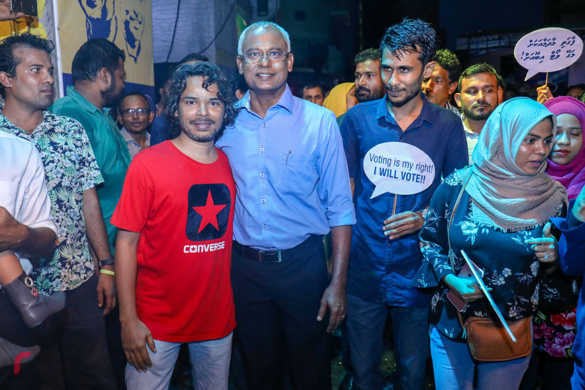 އޯގަސްޓް 15، 2018: ގުޅިފައިވާ އިއްތިހާދުން މައްޗަންގޯޅީގައި ޒުވާނުންގެ ޖަގަހައެއް ހުޅުވުމަށް ކުރިއަށްގެންދިޔަ ރަސްމިއްޔާތަށް ފަހު ގުޅިފައިވާ އިއްތިހާދުގެ ރިޔާސީ ކެނޑިޑޭޓް އިބްރާޙިމް މުހައްމަދު ސޯލިހުގެ ސަޕޯޓަރަކާއިއެކު ފޮޓޯއަކަށް ހުއްޓިވަޑައިގެން. ފޮޓޯ:- މުހައްމަދު ޝަރުހާން/ ރާއްޖެ އެމްވީ