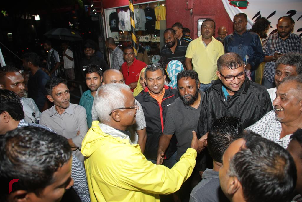 އޮކްޓޫބަރު 2، 2018: ރިޔާސީ އިންތިހާބުގެ ކާމިޔާބީ ފާހަގަކުރުމަށް މާލޭގެ އެކި ސަރަހައްދުތަކުގައި ހިންގަމުންއަންނަ އުފާފާޅުކުރުމުގެ ހަރަކާތްތަކުގެ ތެރެއިން ސުވެނިއަރ ޝޮޕްތަކުން އިންތިޒާމުކޮށްގެން، ޗާންދަނީމަގުގައި އިންތިޚާބީ ރައީސް އިބްރާހިމް މުހައްމަދު ސޯލިހާއި އިންތިޚާބީ ނައިބު ރައީސް ފައިސަލް ބައިވެރިވެވަޑައިގަންނަވަނީ