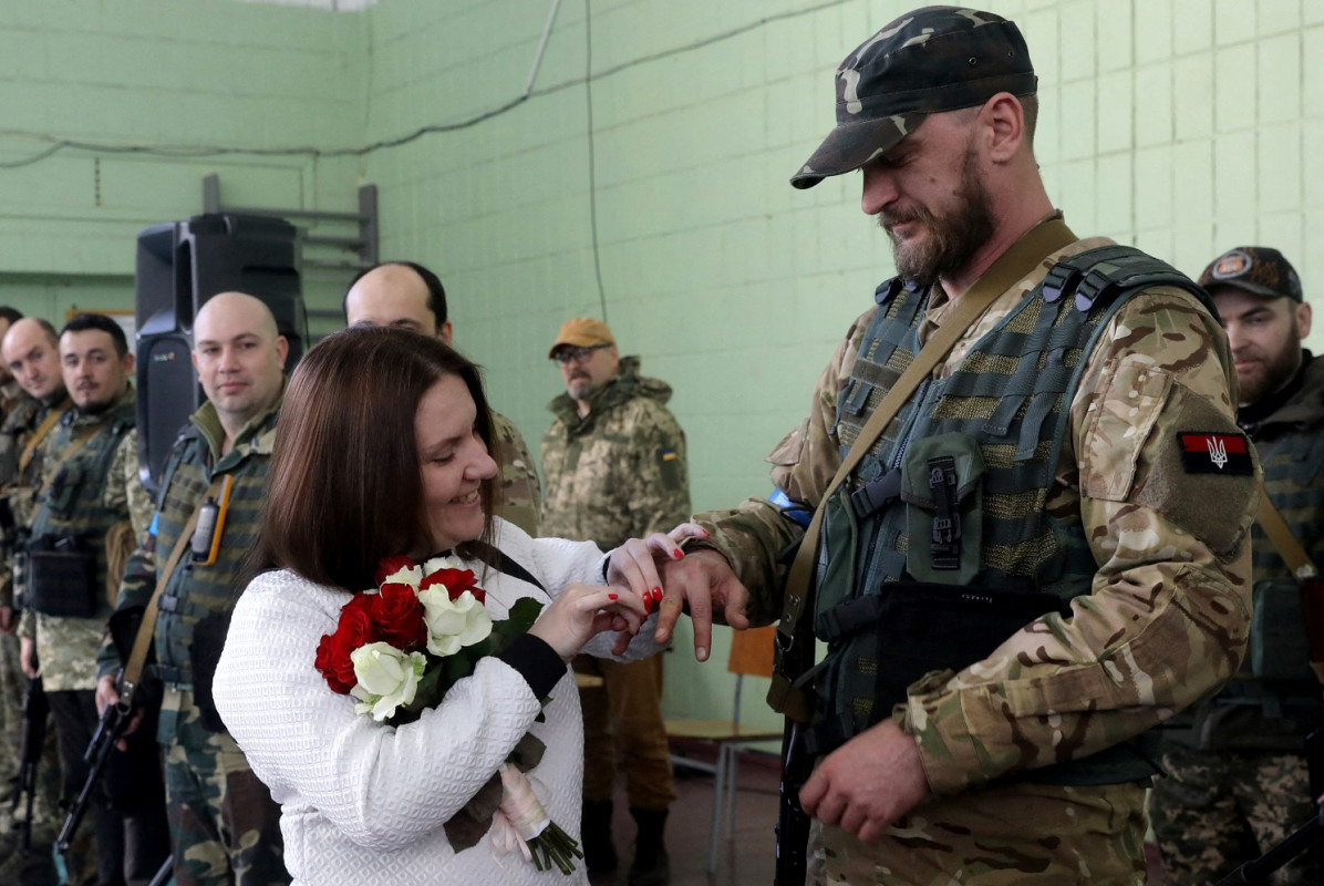 ރަޝިޔާއިން ޔޫކްރެއިންއަށްދޭ ހަމަލާތަށް ކުރިޔަށްދާއިރު، ޔޫކްރެއިންގެ ސަރަހައްދީ ދިފާއީ ބާރުތަކުގެ މެމްބަރުން ކަމަށްވާ ކްސެނިއާ އާއި ރޯމަން ކައިވެނިކޮށްފި. 20 މާޗް 2022 ޔޫކްރެއިންގެ ވެރިރަށް ކީވްގައި. ފޮޓޯ: ރޮއިޓަރސް