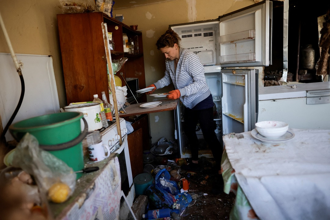 ރަޝިއާގެ މިސައިލް ހަމަލާއެއް އަމާޒުވެ ޔޫކްރެއިންގެ ދެކުނުގެ އަވަށަކަށް ގެއްލުން ލިބިފައިވާއިރު، އެއަވަށުގެ ގެއެއްގެ ބަދިގެ އެގޭ އަންހެނަކު ސާފުކުރަނީ - ފޮޓޯ: ރޮއިޓަރސް