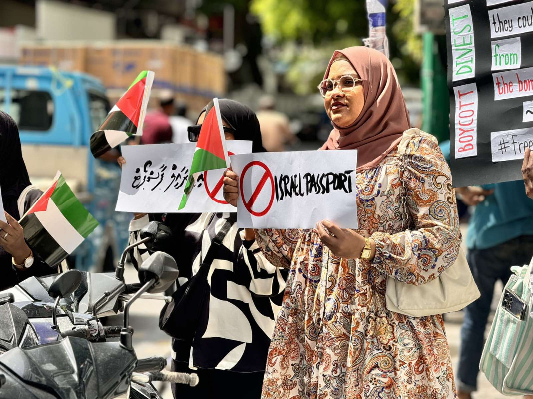 އިޒްރޭލް ޕާސްޕޯޓް މަނާކުރުމަށް ގޮވާލާ ކުރި މުޒާހަރާގެ ތެރެއިން - އެއްވުމަށް ދިޔަ ފަރާތްތަކުން ވަނީ އިޒްރޭލަށް އެެހީތެރިވެދޭ ފަރާތްތަކާއި، އުފެއްދުންތައްވެސް ރާއްޖެއަށް އެތެރެވުން މަނާކުރުމަށް ގޮވާލާ ލިޔެފައިވާ ބޯޑްތައް ހިފައިގެން އަޑު އުފުލާފަ - ފޮޓޯ: ޙުސައިން މަޚްތޫމް