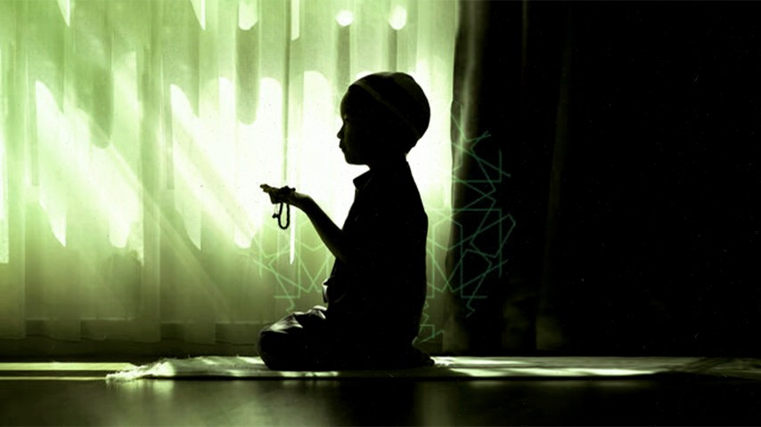 ކުޑަކުއްޖަކު ނަމާދަށް ހުންނަ މަންޒަރު ދައްކައިދޭ ފޮޓޯއެއް