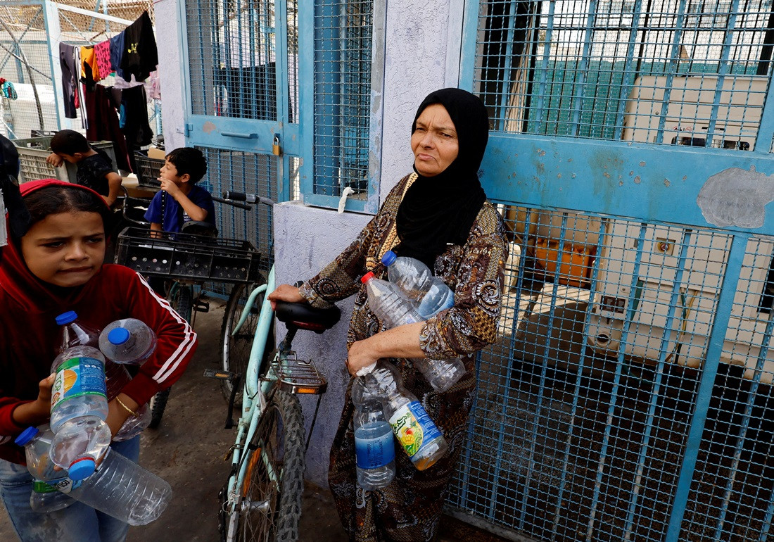 އިސްރާއީލުގެ ހަމަލާތަކާ ގުޅިގެން ގެދޮރު ދޫކޮށް ހިޖުރަކޮށްފައިވާ ފަލަސްތީނު މީހުން، އދ.ން ހިންގާ ސްކޫލެއްގައި ހިމާޔަތް ހޯދަނީ - ފޮޓޯ: ރޮއިޓާސް