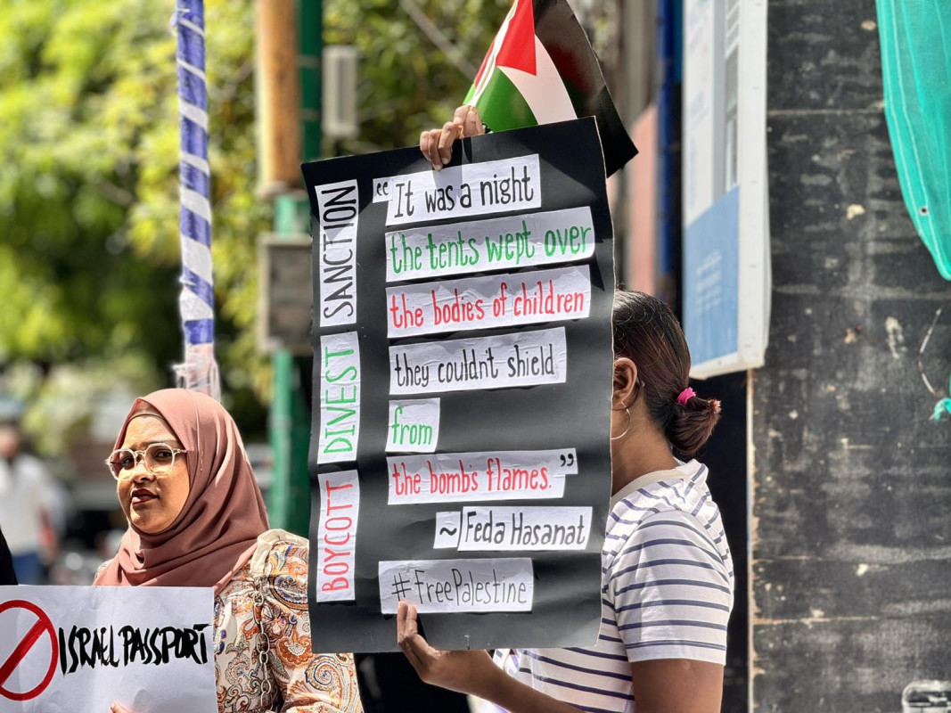 އިޒްރޭލް ޕާސްޕޯޓް މަނާކުރުމަށް ގޮވާލާ ކުރި މުޒާހަރާގެ ތެރެއިން - އެއްވުމަށް ދިޔަ ފަރާތްތަކުން ވަނީ އިޒްރޭލަށް އެެހީތެރިވެދޭ ފަރާތްތަކާއި، އުފެއްދުންތައްވެސް ރާއްޖެއަށް އެތެރެވުން މަނާކުރުމަށް ގޮވާލާ ލިޔެފައިވާ ބޯޑްތައް ހިފައިގެން އަޑު އުފުލާފަ - ފޮޓޯ: ޙުސައިން މަޚްތޫމް