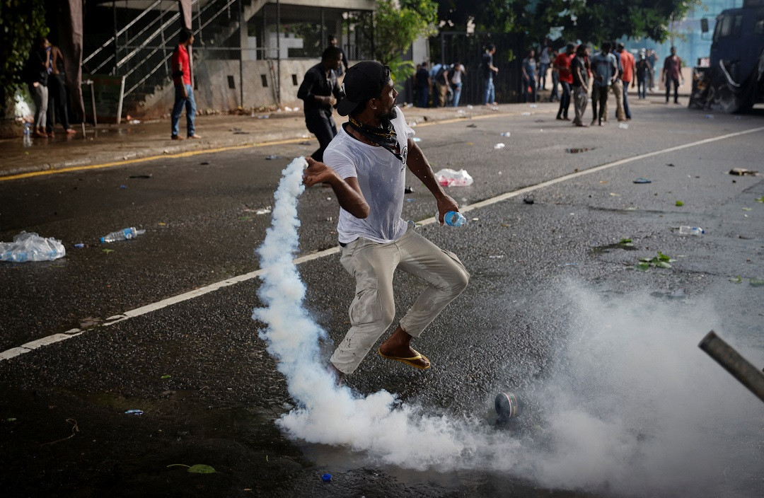 ލަންކާގައި ތެޔޮ ލިބުން ދަތިވުމުގެ ސަބަބުން މުޒާހަރާކުރި މީހުންނާ ފުލުހުންނާ ދެމެދު ކުރިމަތިލުންތައް ހިނގައި ފުލުހުން ބޭނުންކުރި ކަރުނަ ގޭސް އަނބުރާ ފުލުހުންނާ ދިމާލަށް އެއްލަނީ - ފޮޓޯ: ރޮއިޓަރސް