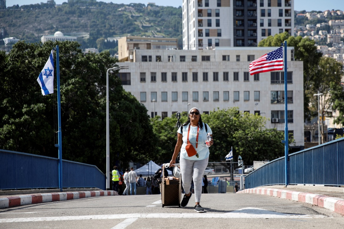 އެމެރިކާގެ ރައްޔިތުން ދަތުރުކުރާ އުޅަނދަކަށް އެރުމަށް ދާ އަންހެނަކު އޭނާގެ ލަގެޖް ހިފައިގެން - ފޮޓޯ: ރޮއިޓާސް