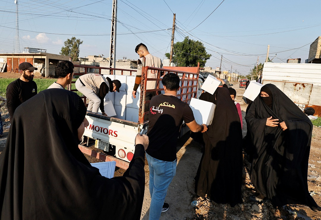 ވޮލެންޓިއަރުން ބަހާ ކާއެއްޗެހި ހިމެނޭ ފޮށިގަނޑު ހޯދުމަށް އިރާގުގެ އެތައް ބަޔަކު ކިއުގައި - ފޮޓޯ: ރޮއިޓަރސް