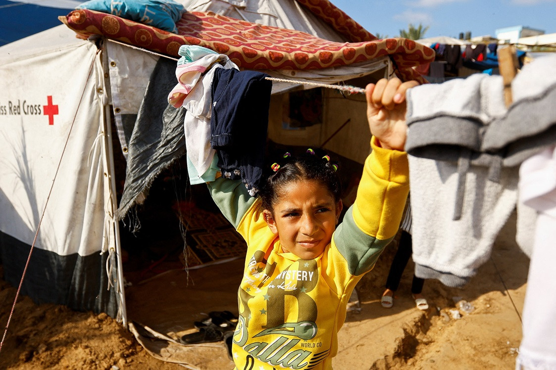 އިސްރާއީލުގެ ހަމަލާތަކާ ގުޅިގެން ގެދޮރު ދޫކޮށް ދާންޖެހުނު  މީހުންގެ ތެރެއިން، ނާސިރު ހޮސްޕިޓަލުގެ ޓެންޓުތަކުގައި ހިޔާވަހިކަން ހޯދާ ކުޑަކުއްޖެއް - ފޮޓޯ: ރޮއިޓަރސް