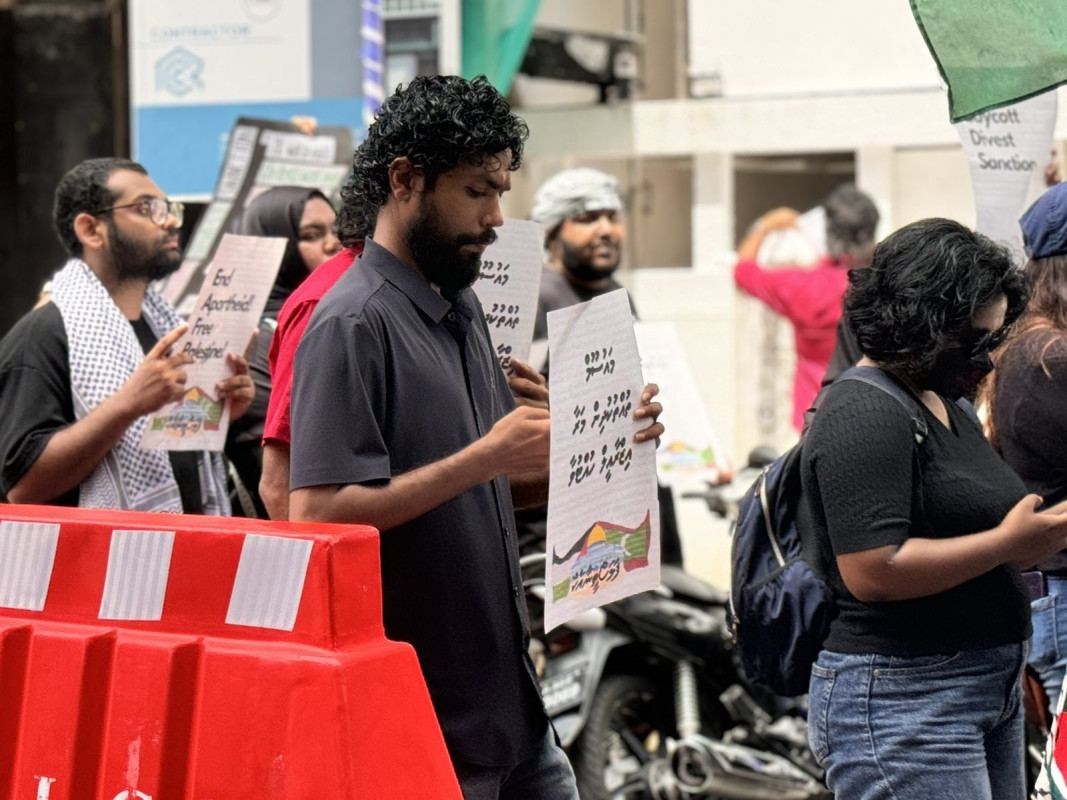 އިޒްރޭލް ޕާސްޕޯޓް މަނާކުރުމަށް ގޮވާލާ ކުރި މުޒާހަރާގެ ތެރެއިން - އެއްވުމަށް ދިޔަ ފަރާތްތަކުން ވަނީ އިސްރާއިލަށް އެެހީތެރިވެދޭ ފަރާތްތަކާއި، އުފެއްދުންތައްވެސް ރާއްޖެއަށް އެތެރެވުން މަނާކުރުމަށް ގޮވާލާ ލިޔެފައި ބޯޑްތައް ހިފައިގެން އަޑު އުފުލާފަ - ފޮޓޯ: ޙުސައިން މަޚްތޫމް