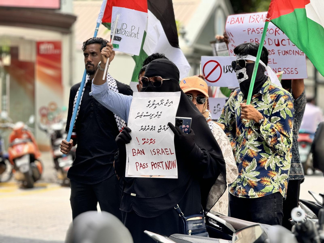 އިޒްރޭލް ޕާސްޕޯޓް މަނާކުރުމަށް ގޮވާލާ ކުރި މުޒާހަރާގެ ތެރެއިން - އެއްވުމަށް ދިޔަ ފަރާތްތަކުން ވަނީ އިސްރާއިލަށް އެެހީތެރިވެދޭ ފަރާތްތަކާއި، އުފެއްދުންތައްވެސް ރާއްޖެއަށް އެތެރެވުން މަނާކުރުމަށް ގޮވާލާ ލިޔެފައި ބޯޑްތައް ހިފައިގެން އަޑު އުފުލާފަ - ފޮޓޯ: ޙުސައިން މަޚްތޫމް