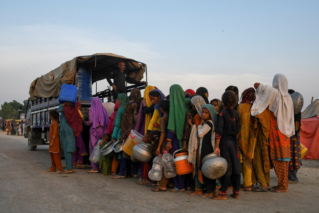 ޕާކިސްތާނުގެ ސެހްވާން ގައި ބޯކޮށް ވާރޭވެހި ފެންބޮޑުވުމާ ގުޅިގެން، ގެދޮރު ދޫކޮށް ދިޔަ މީހުން، އެހީގެ ކޭމްޕެއްގައި ޓްރަކުން ބޯ ފެން ހޯދަނީ - ފޮޓޯ: ރޮއިޓަރސް