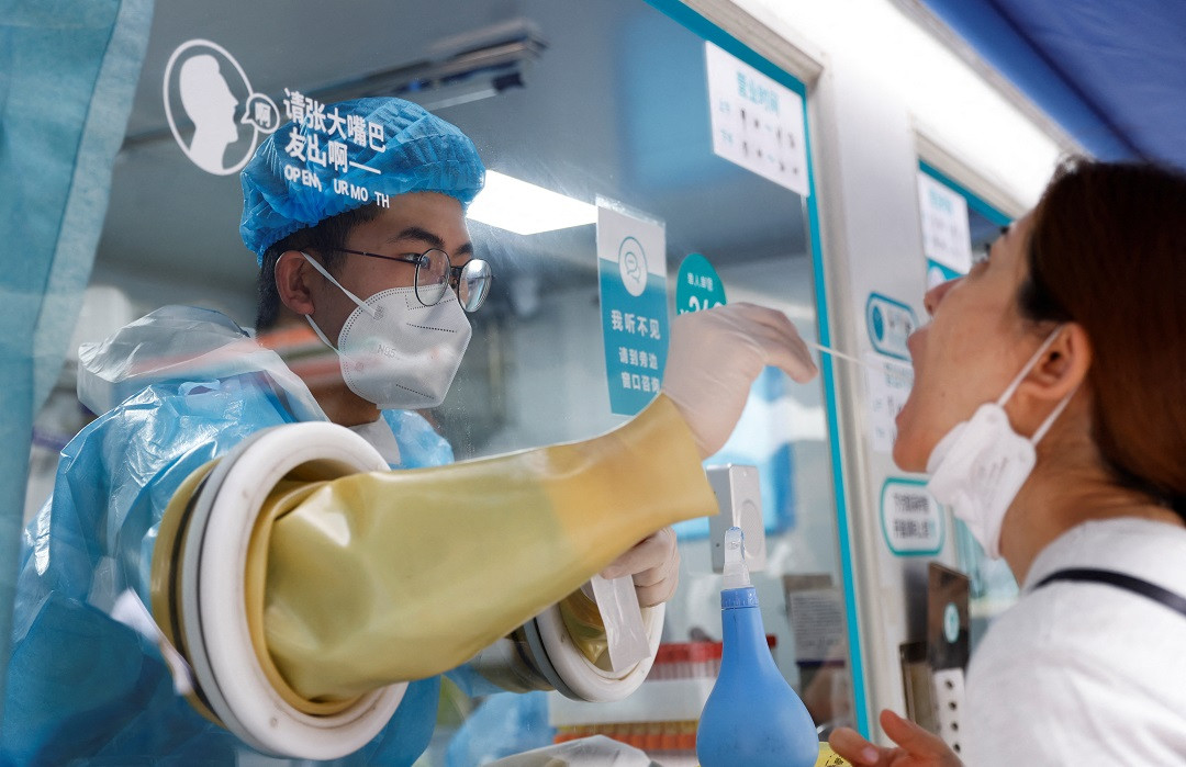 ބެއިޖިންގގައި ޤާއިމުކޮށްފައިވާ ކޮވިޑަށް ޓެސްޓުކުރާ މޮބައިލް ސްޓޭޝަނެއްގައި މީހަކު ޓެސްޓުކުރަނީ - ފޮޓޯ: ރޮއިޓަރސް