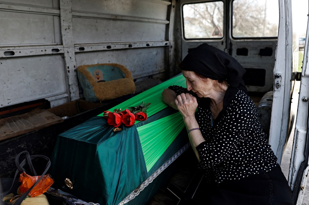 ހަނގުރާމައިގައި މަރުވި ޒުވާނެއްގެ ސަންދޯއް ކައިރީގައި އޭނާގެ މަންމަ ހިތާމަކުރަނީ - ފޮޓޯ: ރޮއިޓަރސް