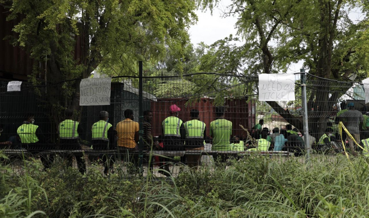 ސިފައިންނާއި ފުލުހުންނަށް ޚާއްސަ ކޮށްގެން ހުޅުމާލޭގައި ހަދަމުންދާ އިމާރާތުގެ މަސައްކަތް ކުރަމުންދާ ތައިލެންޑުގެ އައިލެންޑް އެކްސްޕާޓުގެ ބިދޭސީންނަށް މުސާރަ ނުދޭކަމަށް ބުނެ، 13 ޖުލައި 2020 ގައި ކުރި މުޒާހަރާގެ ތެރެއިން - ހަމަނުޖެހުން ހިންގި ބިދޭސީން ލޭބާ ކުއާޓާޒްގެ ކޮރިޑޯގެ ތެރޭގައި އިށީނދެގެން، އެމީހުން ގޮވަމުންދަނީ އަބުރާ ގައުމަށް ފޮނުވައިދިނުމަށާއި، މުސާރަ ދިނުމަށް - ފޮޓޯ: ރާއްޖެއެމްވީ