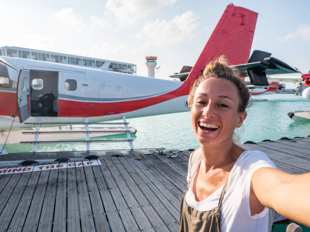 Woman takes selfie at seaplane airport, ready for departure