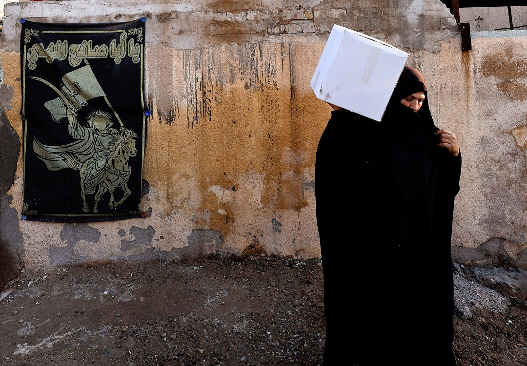 ވޮލެންޓިއަރުން ބަހާ ކާއެއްޗެހި ހިމެނޭ ފޮށިގަނޑެއް ހިފައިގެން ހުރި އަންހެނެއް - ފޮޓޯ: ރޮއިޓަރސް