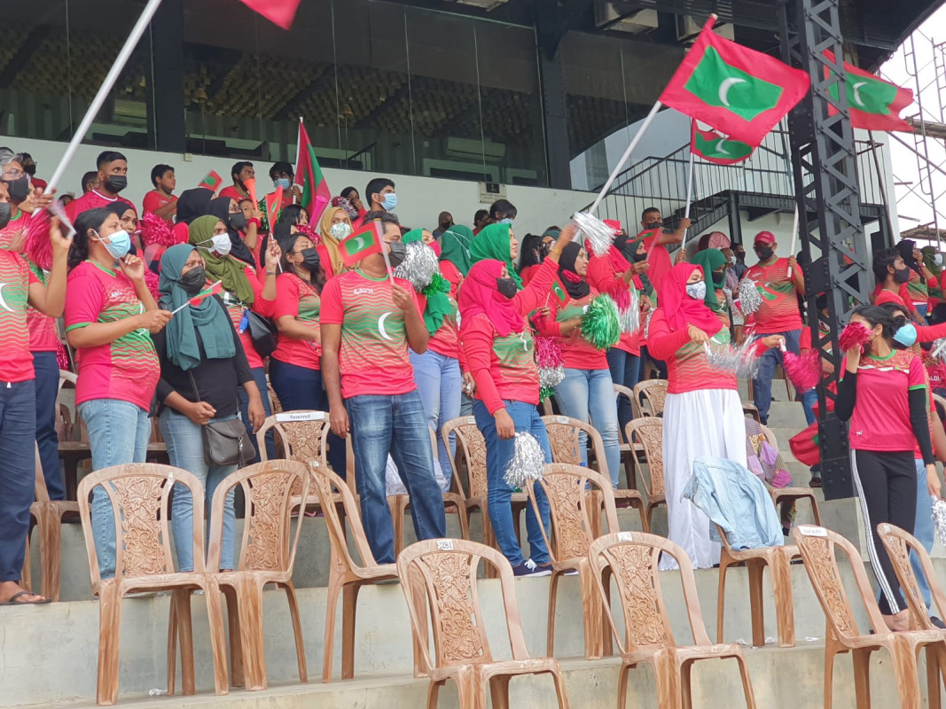 "މަހިންދަ ރާޖަޕަކްސަ ޓްރޮފީ" ފުޓްބޯޅަ މުބާރާތުގައި ދިވެހިރާއްޖެ އާއި ސްރީލަންކާ ބައްދަލުކުރާ މެޗުގައި، ދިވެހި ޓީމަށް ހިތްވަރު ދިނުމަށް ދަނޑަށް ވަދެ ތިބި ދިވެހި ސަޕޯޓަރުން - މޫސުން ގޯސްވުމުގެ ސަބަބުން މެޗުތައް ފަސްކުރުމާއި ގުޅިގެން، މިހާރު ތާވަލުކޮށްފައިވާ ގޮތުން މުބާރާތް ކުރިއަށްދާނީ އަންގާރަ ދުވަހުން ފެށިގެން މި މަހުގެ 19 ވަނަ ދުވަހުގެ ނިޔަލަށް - ފޮޓޯ: މުޙައްމަދު ފައިސަލް