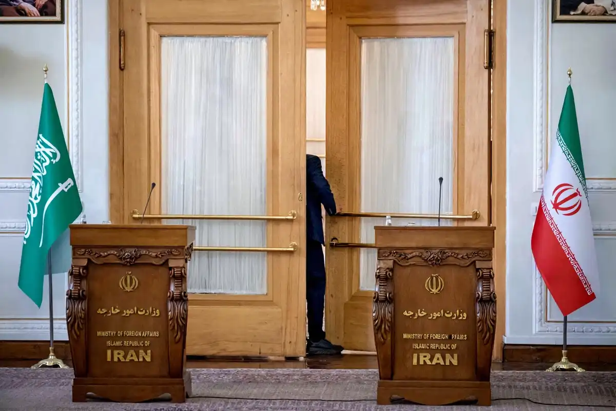 ތެހެރާންގައި ހުންނަ އީރާނުގެ ފޮރިން މިނިސްޓްރީގެ އިމާރާތުގެ ކޮންފަރެންސް ހޯލެއްގެ ދޮރުމަތީގައި، އީރާނުގެ ދިދައަކާއި ސައުދީ އަރަބިއްޔާގެ ގައުމީ ދިދައެއްގެ ކައިރީގައި ސައުދީގެ އޮފިޝަލަކު މަޑުކޮށްލައިގެން. މި ފޮޓޯ ނަގާފައިވަނީ 2023 ވަނަ އަހަރުގެ ޖޫން މަހުގެ 17 ވަނަ ދުވަހު.