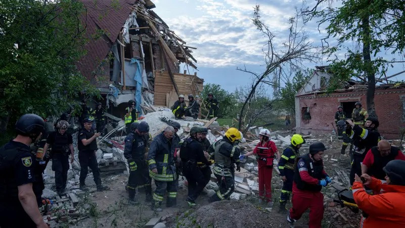 ޔޫކްރެއިންގެ ޚަރްކީވްއަށް ރަޝިޔާއިން ދިން ވައިގެ ހަމަލާގައި ހަލާކުވި އިމާރާތަކުން ޒަހަމްވި މީހަކު ސްޓްރެޗަރެއްގައި އެމްބިއުލާންސަށް އަރުވަނީ