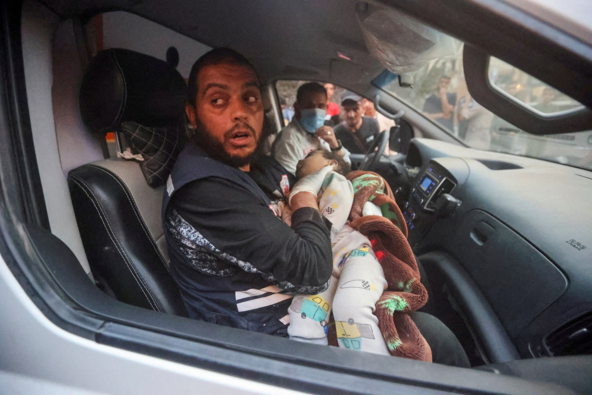 އިޒްރޭލުގެ ހަމަލާތަކުގައި ހަލާކުވި ގެއަކުން ފަލަސްތީނުގެ ކުޑަކުއްޖަކު ގޮވައިގެން ޕެރަމެޑިކް އޮފިސަރެއް ދަނީ - ފޮޓޯ: ރޮއިޓާސް