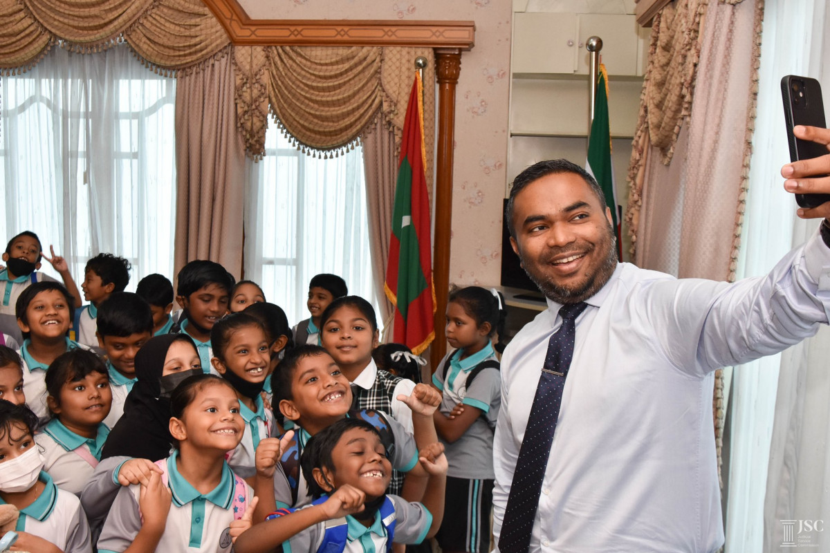 އަހްމަދިއްޔާ އިންޓަނޭޝަނަލް ސްކޫލްގެ ގްރޭޑް 1ގެ ދަރިވަރުން ސްޕްރީމް ކޯޓަށް ޒިޔާރަތްކުރުން, ފަނޑިޔާރު މަހާޒް އަލީ ޒާހިރު ދަރިވަރުންނާއެކު ސެލްފީ ނަންގަވަނީ - ފޮޓޯ: ޖުޑީޝަލް ސަރވިސް ކޮމިޝަން