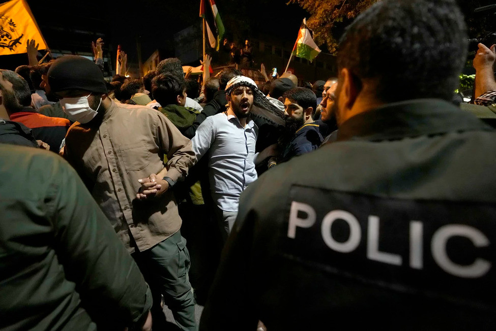 އިޒްރޭލާ ދެކޮޅަށް ކުރި މުޒާހަރާގެ ތެރެއިން، އީރާނުގެ ތެހެރާނުގައި ހުންނަ ފަރަންސޭސި އެމްބަސީއަށް ހަމަލާ ދޭން އުޅުނު މީހުން ހުއްޓުވަން ފުލުހުން މަސައްކަތްކުރަނީ --- ފޮޓޯ: އޭޕީ