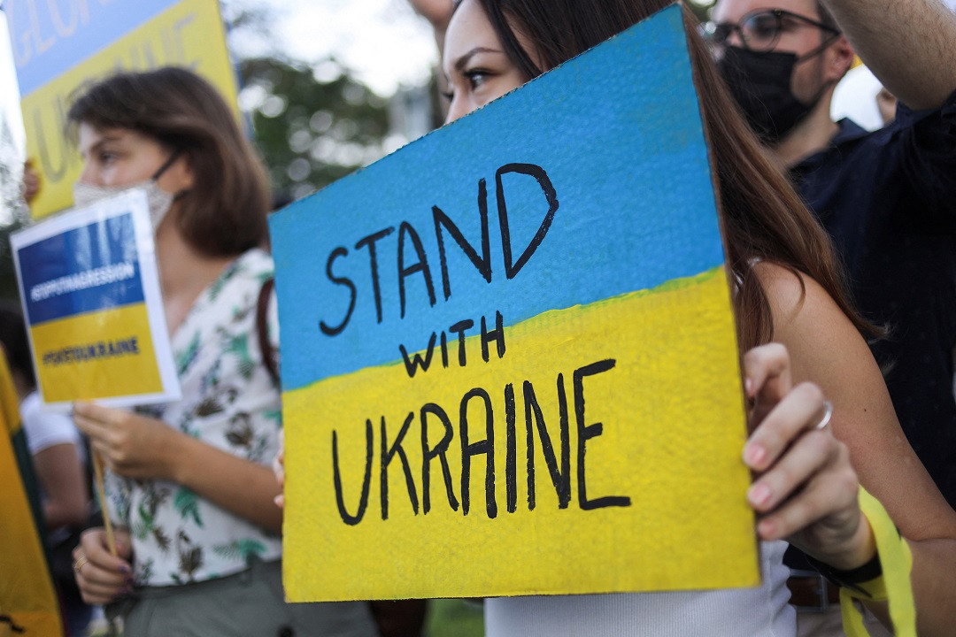 ރަޝިއާއިން ޔޫކްރެއިން އަށް ދެމުންދާ ހަމަލާތައް ހުއްޓުވުމަށް ގޮވާލާ ކުރެވުނު މުޒާހަރާއެއްގެ ތެރެއިން، ގިނަ އަދަދެއްގެ ބަޔަކު ދަނީ އެމީހުން ތިބީ ޔޫކްރެއިނާ އެކުގައިކަމަށް ބުނެ ހިޔާލު ފާޅުކުރަމުން - ފޮޓޯ: ރޮއިޓަރސް