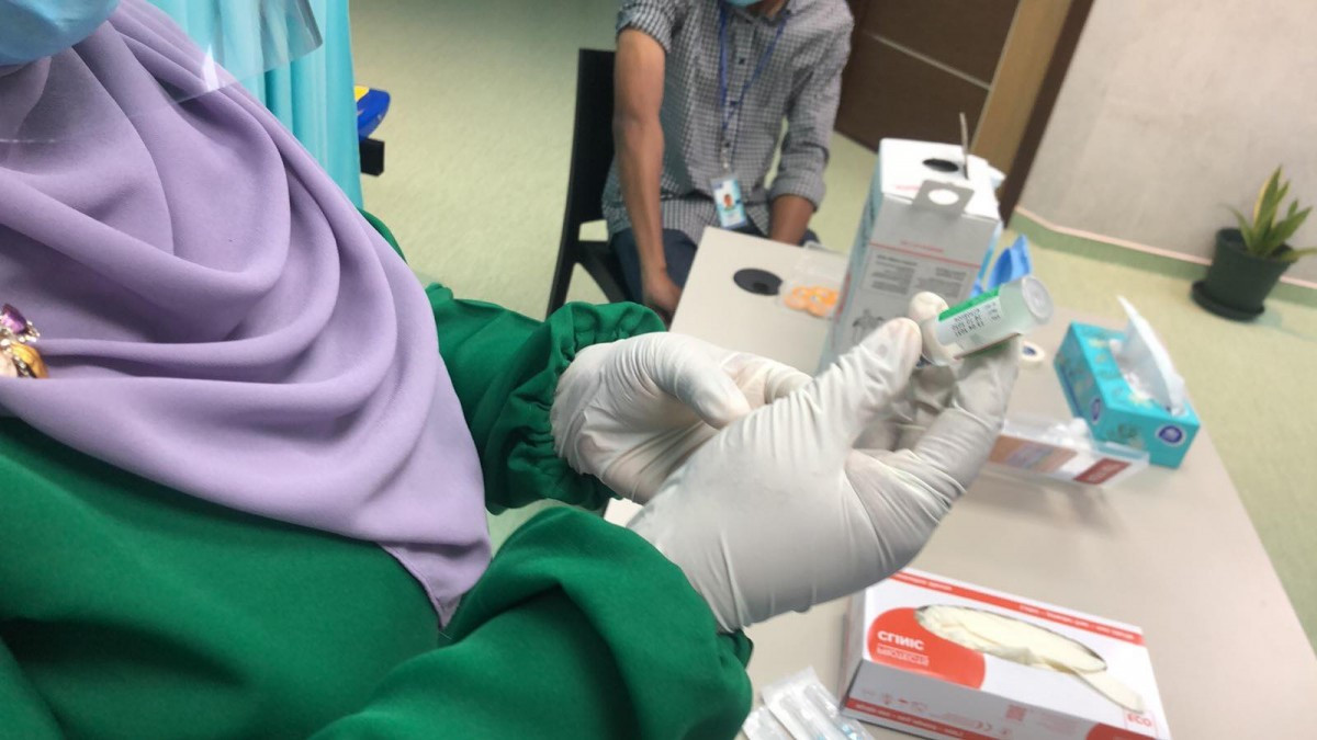 Healthcare official handling vaccine dose