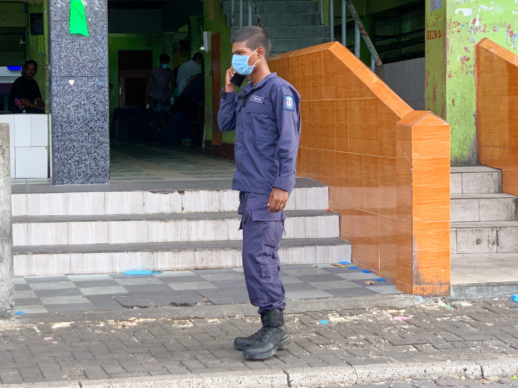 މާސްކު އަޅައިގެން ހުރި ފުލުހަކު މަސްމާރުކޭޓް ކުރިމަތީގައި މަޑުކޮށްލައިގެން - ބާޒާރުމަތި އަދި ފިހާރަތަކަށް ދާއިރު ވެސް މާސްކު އެޅުމަށް ޑޮކްޓަރުން އިރުޝާދު ދެއްވާ - ފޮޓޯ: ރާއްޖެއެމްވީ