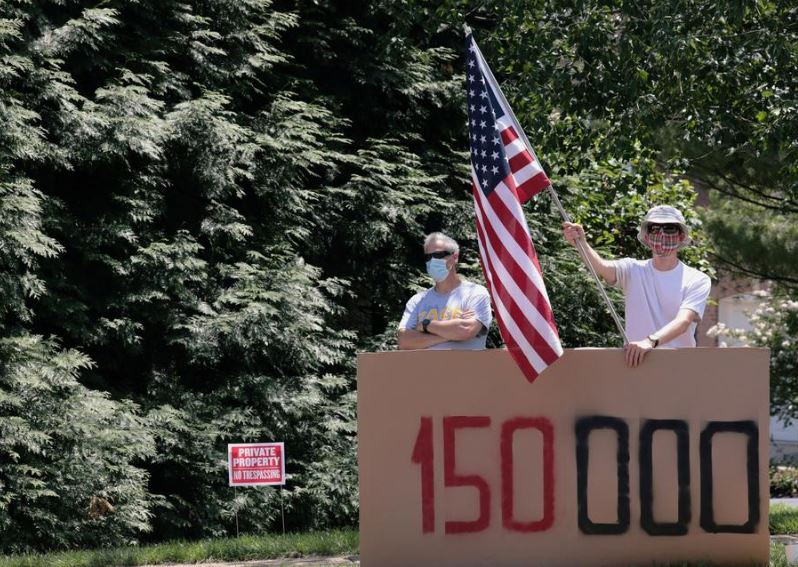 އެމެރިކާގައި ކޮވިޑް-19 ޖެހިގެން މަރުވި މީހުންގެ އަދަދު ޖަހާފައިވާ ތަނެއްގައި ބަޔަކު އެމެރިކާގެ ދިދަ ނަގައިގެން