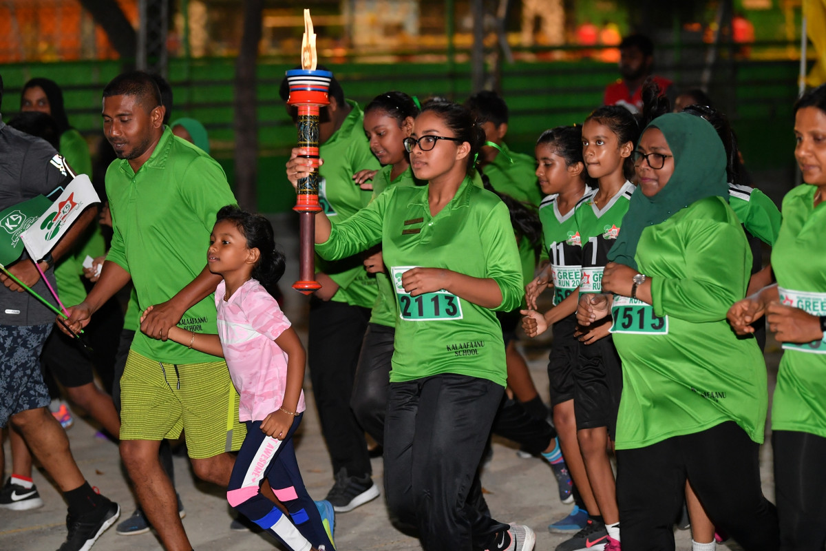 6 ޖުލައި 2019 --ގްރީން ރަންގެ ދަންމަރު ހިފައިގެން ކަލާފާން ސުކޫލްގެ ދަރިވަރަކު ދުވާއިރު، ޔޫތު މިނިސްޓަރު މްހަލޫފު އޭނާގެ ދަރިކަނބަލުން އަތުގައި ހިތްޕަވައިގެން ދުއްވަވަނީ ފޮޓޯ: ރައީސް އޮފީސް