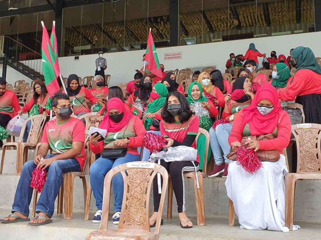 "މަހިންދަ ރާޖަޕަކްސަ ޓްރޮފީ" ފުޓްބޯޅަ މުބާރާތުގައި ދިވެހިރާއްޖެ އާއި ސްރީލަންކާ ބައްދަލުކުރާ މެޗުގައި، ދިވެހި ޓީމަށް ހިތްވަރު ދިނުމަށް ދަނޑަށް ވަދެ ތިބި ދިވެހި ސަޕޯޓަރުން - ފޮޓޯ: މުޙައްމަދު ފައިސަލް