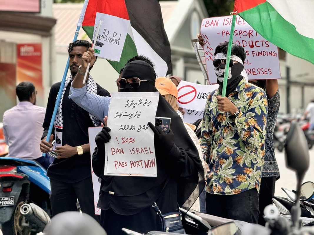 އިޒްރޭލް ޕާސްޕޯޓް މަނާކުރުމަށް ގޮވާލާ ކުރި މުޒާހަރާގެ ތެރެއިން - އެއްވުމަށް ދިޔަ ފަރާތްތަކުން ވަނީ އިސްރާއިލަށް އެެހީތެރިވެދޭ ފަރާތްތަކާއި، އުފެއްދުންތައްވެސް ރާއްޖެއަށް އެތެރެވުން މަނާކުރުމަށް ގޮވާލާ ލިޔެފައި ބޯޑްތައް ހިފައިގެން އަޑު އުފުލާފަ - ފޮޓޯ: ޙުސައިން މަޚްތޫމް