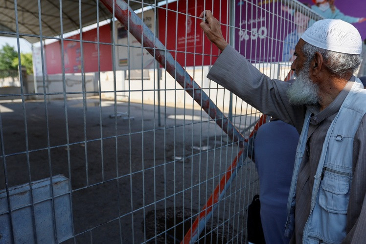 ޣައްޒާދޫކޮށް ދިއުމުގެ ހުއްދަ ލިބޭނެކަމުގެ އުއްމީދުގައި، މިސްރުގެ ރަށްވެހިކަން ލިބިފައިވާ ފަލަސްތީނު މީހުން ރަފާ ބޯޑަރު ބޭރުގައި - ފޮޓޯ: ރޮއިޓާސް