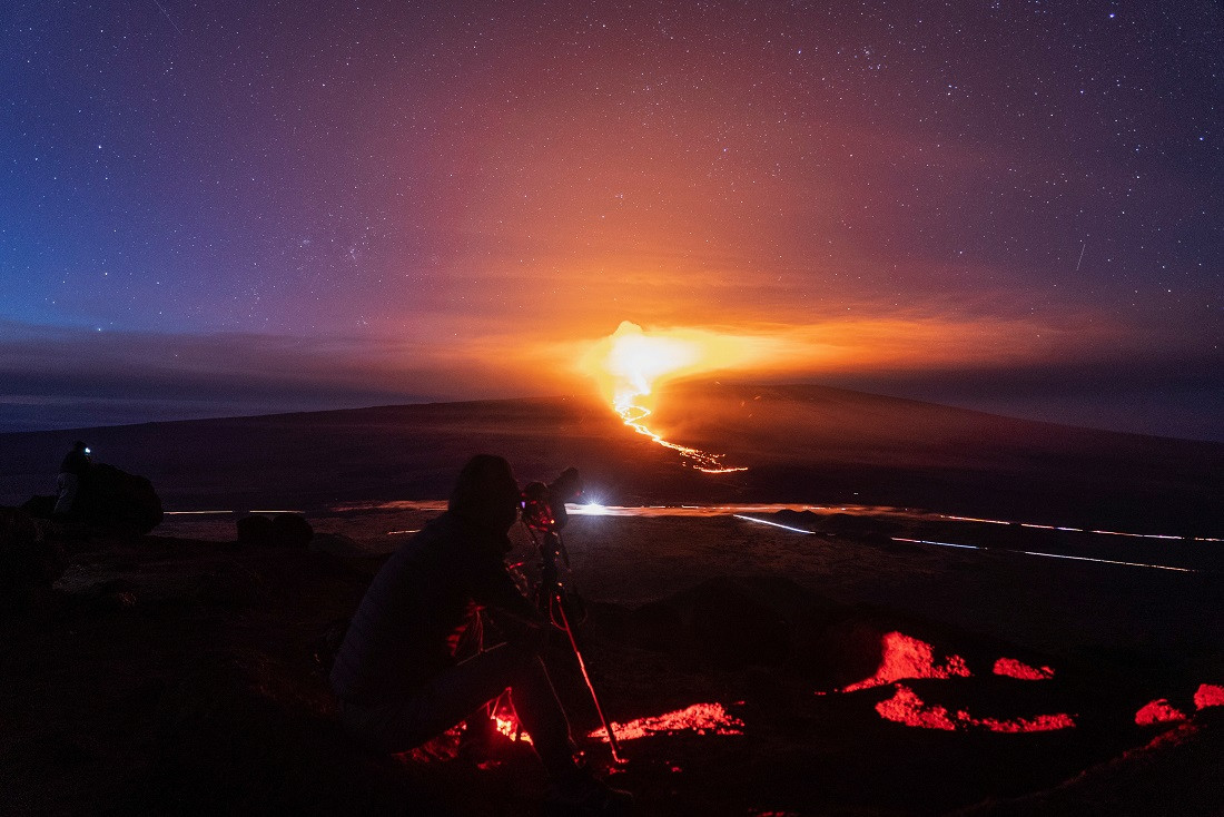 ހަވާއީގެ މައުނާ ލޯއާ އަލިފާން ފަރުބަދަ ގޮވާތަނުގެ ފޮޓޯ ނެގުމަށް މީހަކު ކެމެރާއެއް ހިފައިގެން. - ފޮޓޯ: ރޮއިޓަރސް