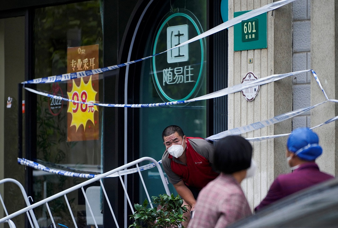 ލޮކްޑައުންކޮށްފައިވާ ޝަންގްހާއީގައި، ބަންދުކޮށްފައިވާ އިމާރާތެއްގެދޮށުގައި ބަޔަކު ހަރަކާތްތެރިވަނީ - ފޮޓޯ: ރޮއިޓަރސް