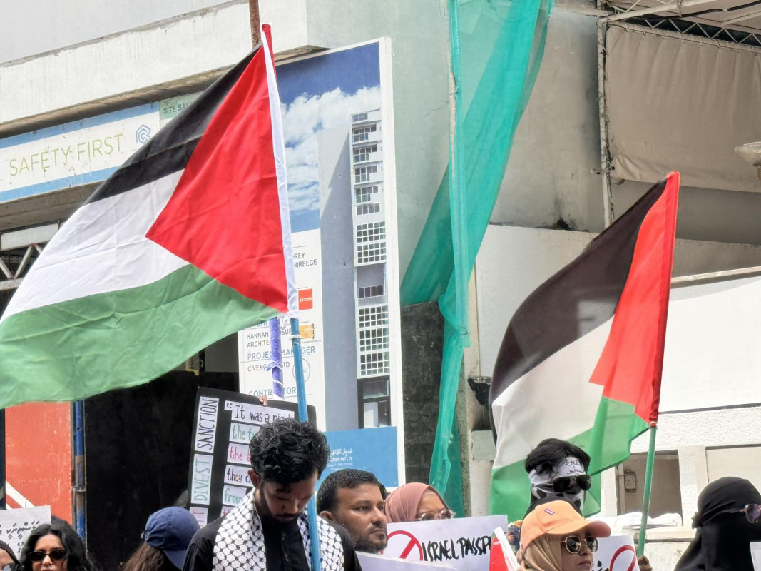 އިޒްރޭލް ޕާސްޕޯޓް މަނާކުރުމަށް ގޮވާލާ ކުރި މުޒާހަރާގެ ތެރެއިން - އެއްވުމަށް ދިޔަ ފަރާތްތަކުން ވަނީ އިޒްރޭލަށް އެެހީތެރިވެދޭ ފަރާތްތަކާއި، އުފެއްދުންތައްވެސް ރާއްޖެއަށް އެތެރެވުން މަނާކުރުމަށް ގޮވާލާ ލިޔެފައިވާ ބޯޑްތައް ހިފައިގެން އަޑު އުފުލާފަ - ފޮޓޯ: ޙުސައިން މަޚްތޫމް