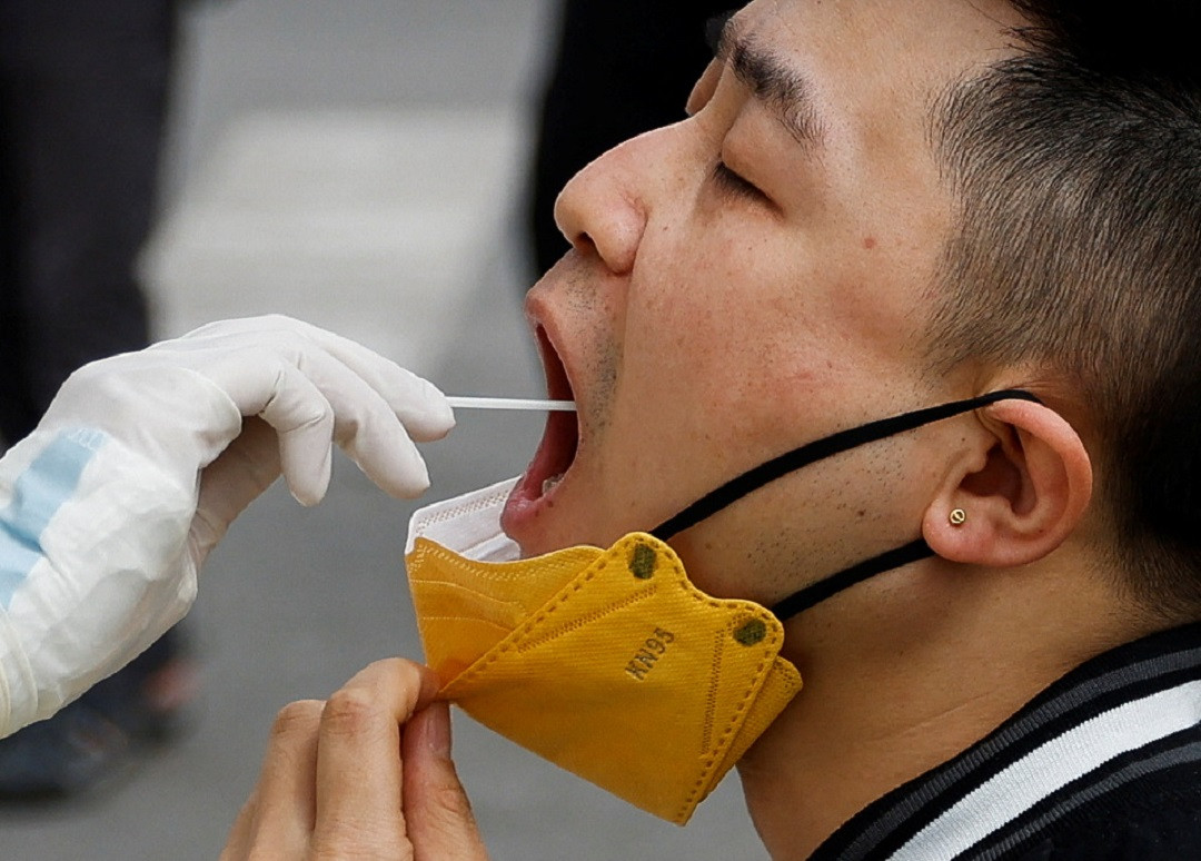 ކޮވިޑް ކޭސްތައް އިތުރުވެ ބެއިޖިންގގެ މުޅި އާބާދީ ޓެސްޓުކުރަން ފަށާފައިވާ ދަނޑިވަޅުގައި އެސިޓީގައި ދިރިއުޅޭ މީހަކު ޓެސްޓުކުރަނީ - ފޮޓޯ: ރޮއިޓަރސް