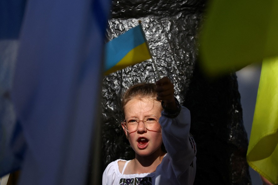 ޔޫކްރެއިންގެ މިނިވަން ދުވަހުގެ އެއްވުމުގެ ތެރެއިން, ލަންޑަންގެ ޑައުނިންގ ސްޓްރީޓްގައި މުޒާހަރާކުރަމުންދާ މީހުންގެތެރޭގައި ހުރި ކުޑަކުއްޖެއް - ފޮޓޯ: ރީޖަނަލް އެއަރޕޯޓްސް