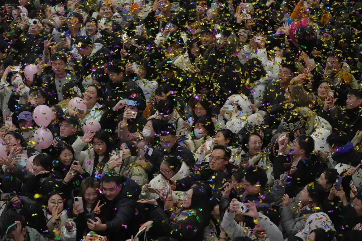 ޗައިނާގެ ބެއިޖިންގައި ހުންނަ ވިޔަފާރި މަރުކަޒެއްގައި ބޭއްވި އައު އަހަރުގެ ކައުންޓްޑައުން ހަރަކާތުގެ ތެރެއިން، 2026 ވަނަ އަހަރު ފެށުން ފާހަގަކުރަމުންދިޔަ މީހުންގެ ގަޔަށް ކޮންފެޓީ ބުރުވައި އުފާފާޅު ކުރަނީ - ފޮޓޯ: އޭޕީ