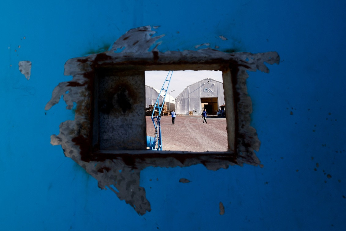 އިސްރާއީލާއި ހަމާސްއާ ދެމެދު ހިނގަމުންދާ ހަނގުރާމަ ކުރިއަށްދާއިރު، އދ.ގެ ސްޓޯރޭޖް ފެސިލިޓީއަކަށް އެހީގެ ޓްރަކްތައް އައުމުން އދ.ގެ މަސައްކަތްތެރިން ދަނީ - ފޮޓޯ: ރޮއިޓާސް