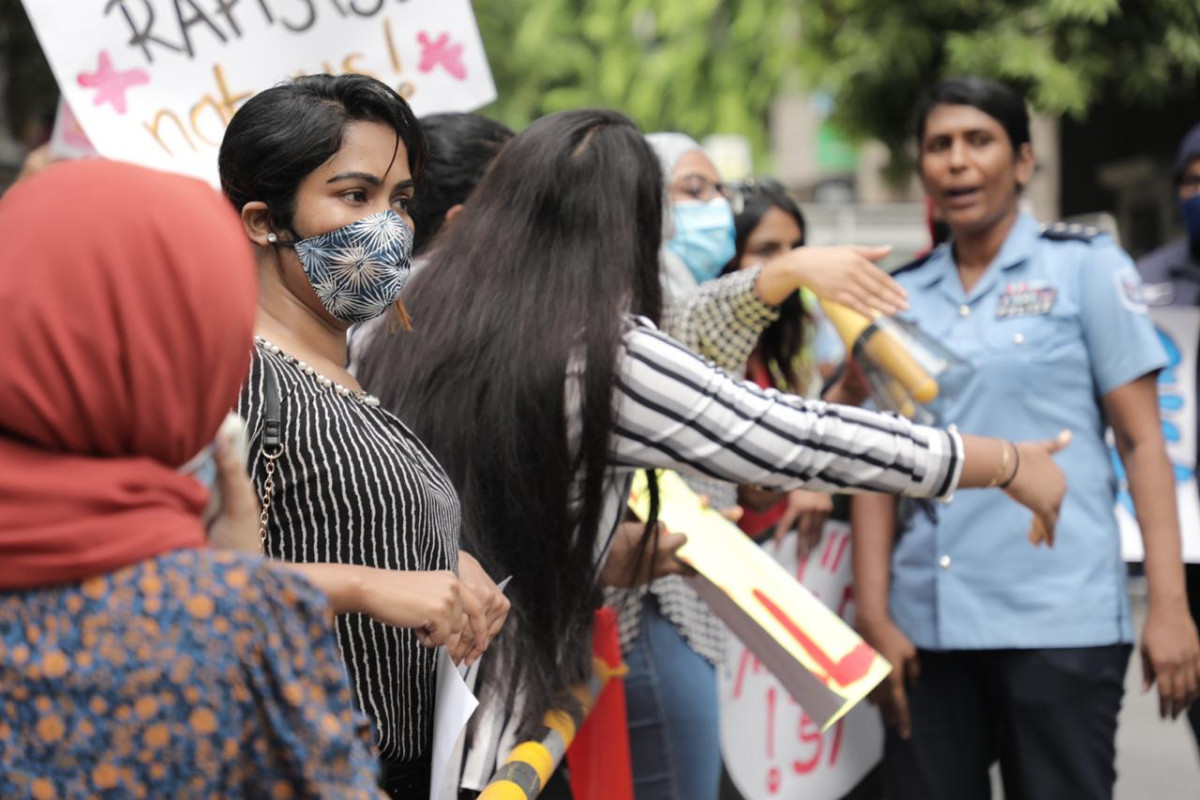 އަންހެނުންނާއި ކުޑަކުދިންނަށް ކުރާ ޖިންސީ އަނިޔާއާއި ދެކޮޅަށް ވޮއިސް އޮފް ޗިލްޑްރަންސްގެ ފަރާތުން ކުރިއަށް ގެންދިއަ މުޒާހަރާގެ ތެރެއިން، މި މުޒާހަރާގެ ބައިވެރިންވަނީ އެކި އެކި ލިޔުންތައް ލިޔެފައިވާ ޕޯސްޓަރު ހިފައިގެން އަޑު އުފުލާފައި - ފޮޓޯ: ރާއްޖެއެމްވީ